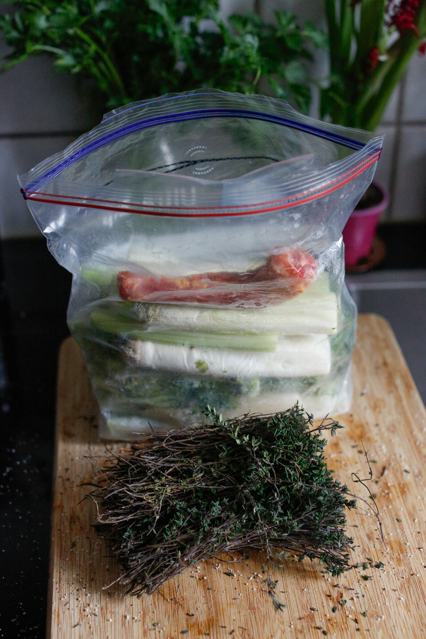 Make sure to save all your scraps in a freezer bag. I collect scraps over time and once it's full I make a broth. Here, I added in the neck of the chicken and the ends of the thyme branches