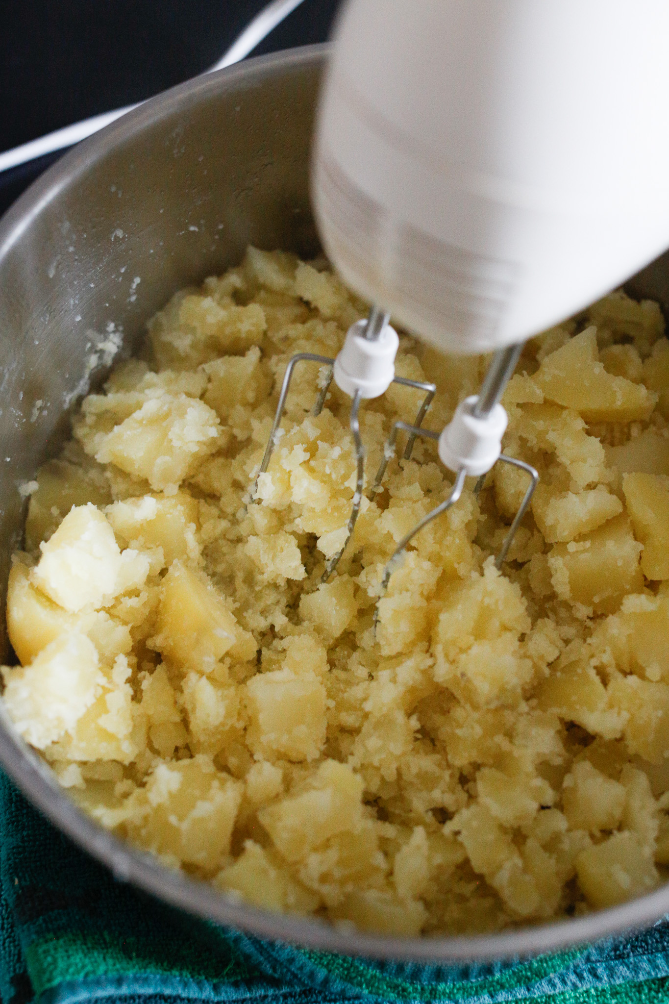 By pre-crushing you prepare the potatoes for an easier mix. If you have a standing mixer, hold the mixer in your hand and crush your potatoes