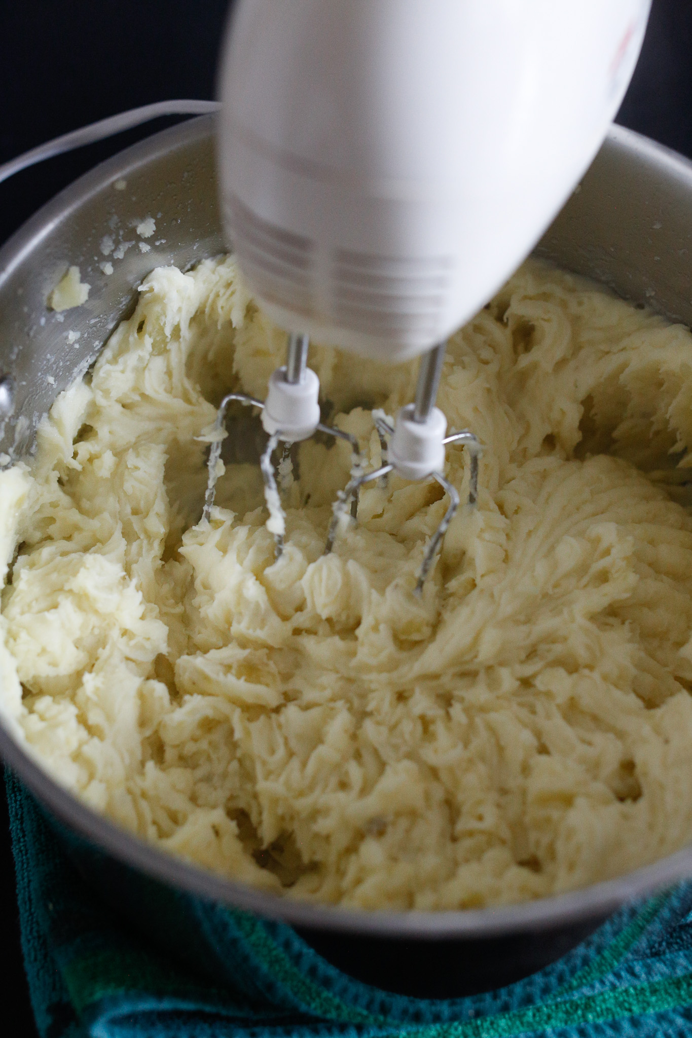 As you beat, continue adding in your milk. Your potatoes will get creamier and creamier