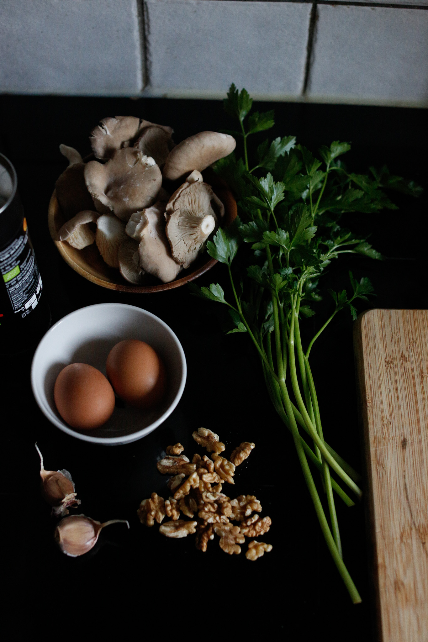 All your ingredients ready to cook eggs, oyster mushrooms, parsley walnuts, olive oil, garlic