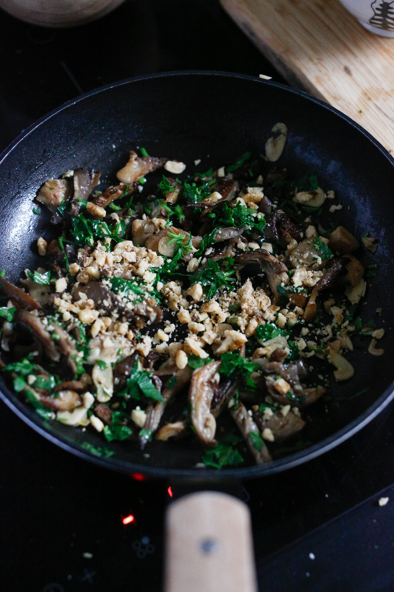 Once your mushrooms has soaked up all the water and are cooked, add in your parsley and walnuts