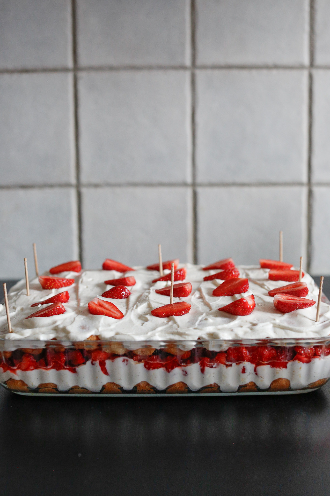 I cut my reserved whole strawberries in half lengthwise and use them as slice markers. One per slice, 4 across and 5 down. 20 slices total on my cake. Add your toothpicks in for the saran wrap.