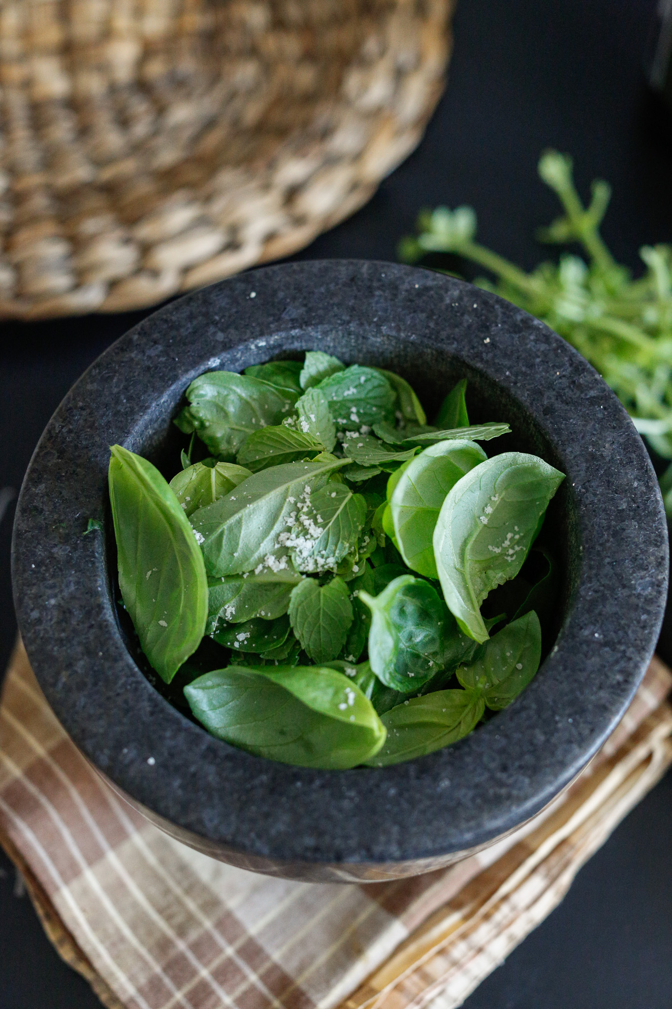 Add in your remaining leaves and a small pinch of salt. The salt helps break down the leaves but you can over salt so be mindful. The parmesan cheese will also be adding lots of salt