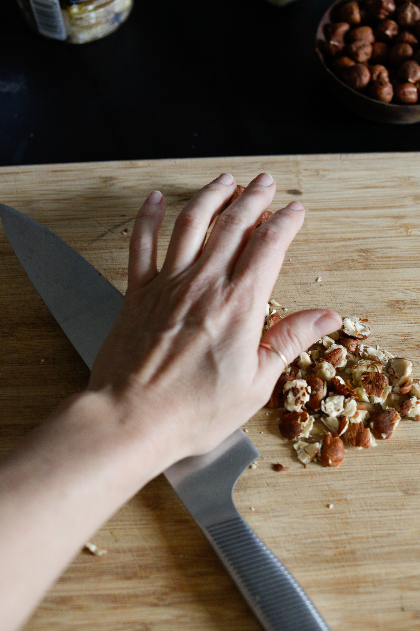 Prepare your hazelnuts. I start by crushing them with the side of my knife to ease the chopping process.