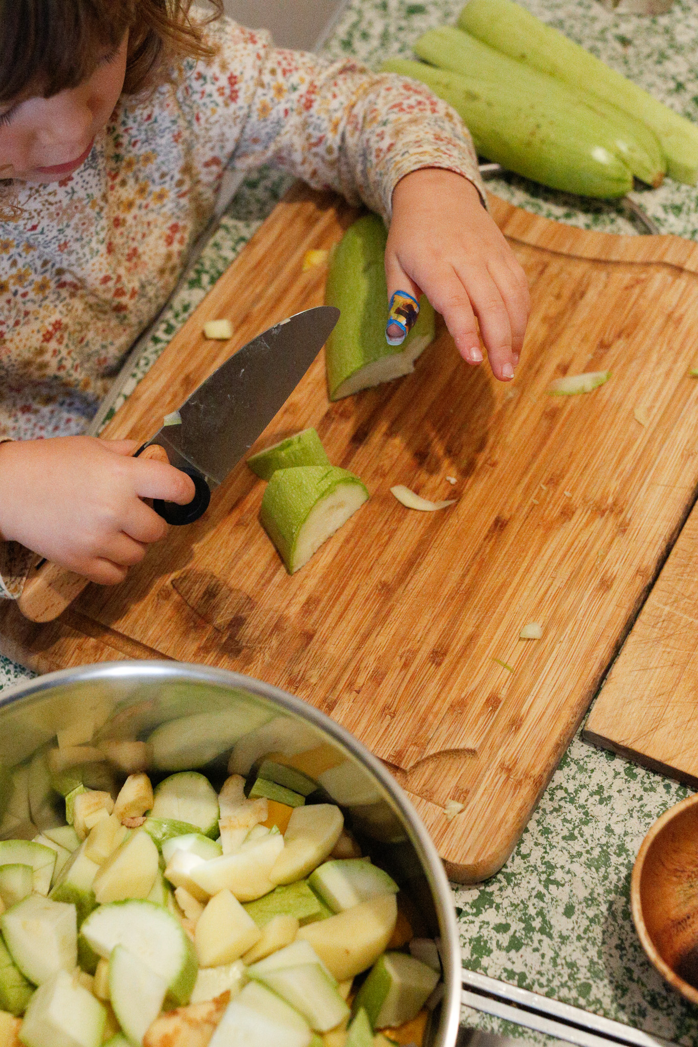 I put the soup pot right next to her so that she can toss in her cuts as she goes. She loved this.