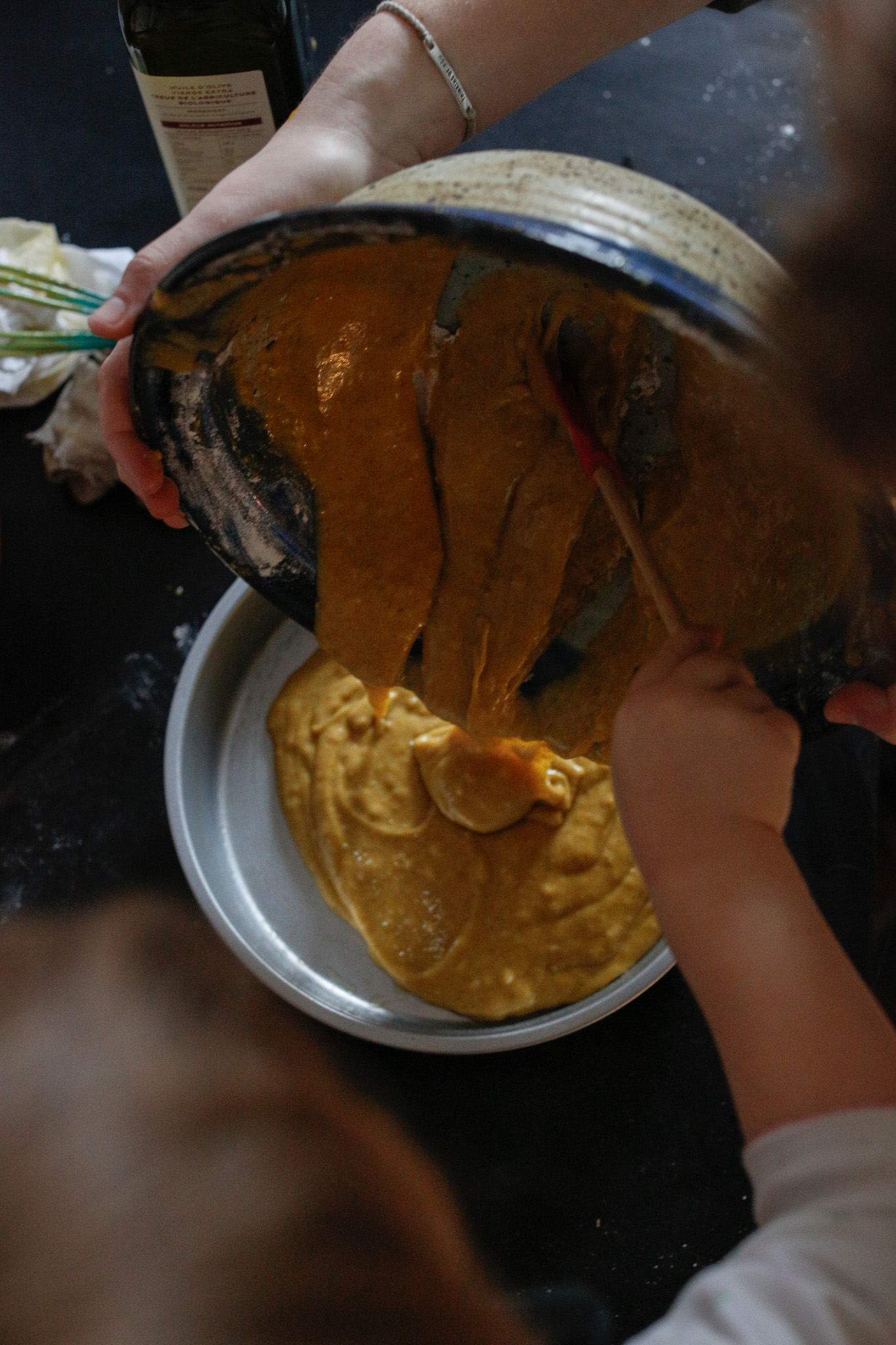 With the help of Uncle Alex and her kiddo spatula Q slowly transfers out the batter into her butter pan.