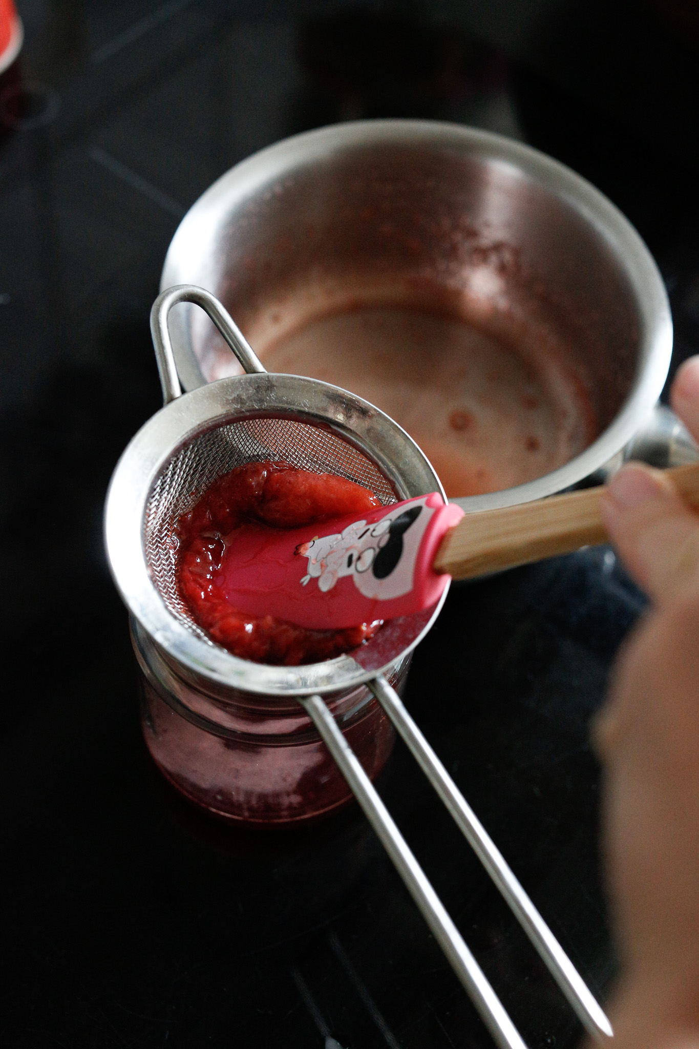 Using a spatula (this is a small kids spatula) squish your strawberries to extract the most juice. You could also blend all this together to make a thicker syrup more like a coulis.