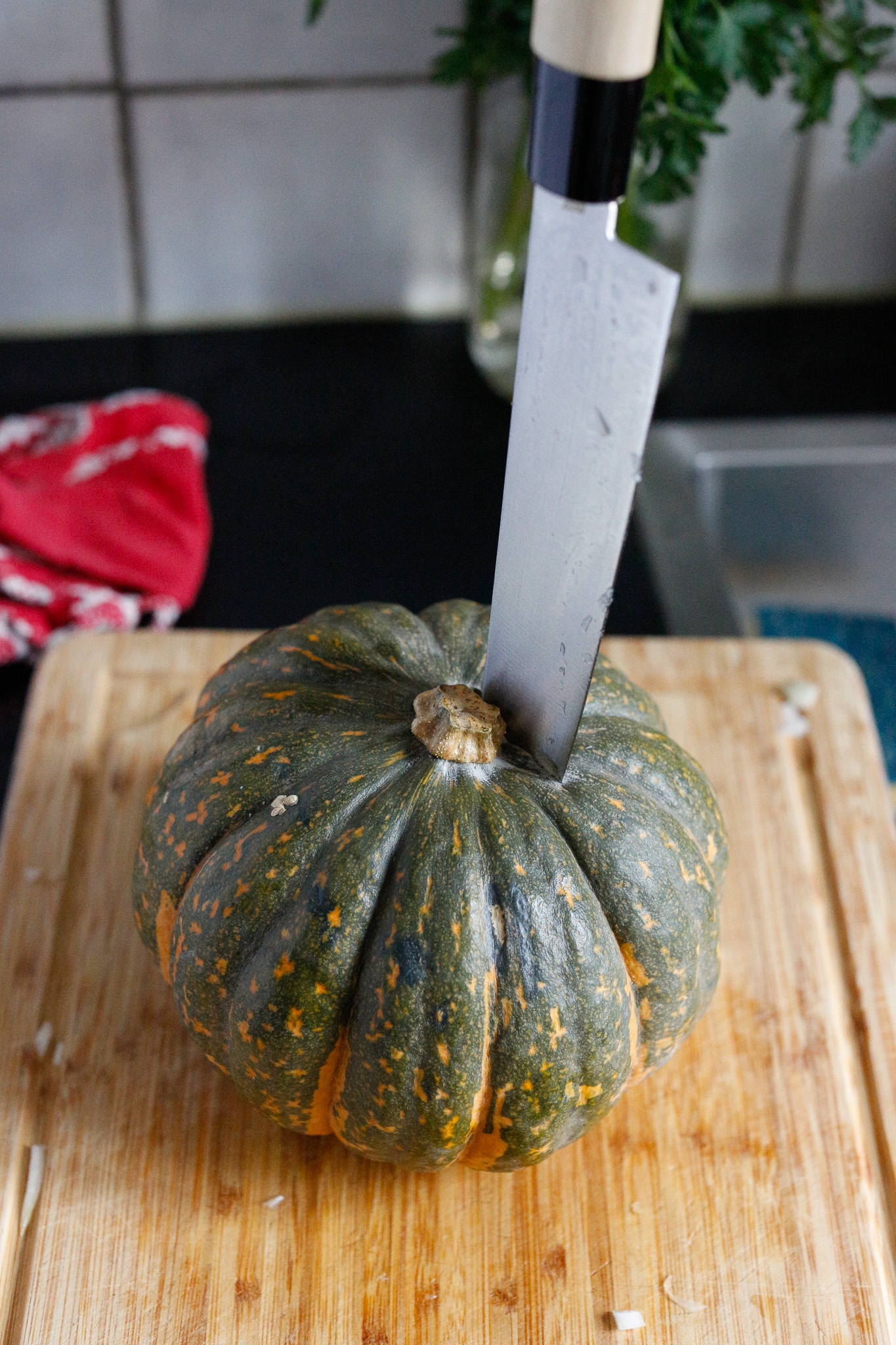 To cut up your kabocha start with the point of a sharp knife into the top of the squash.