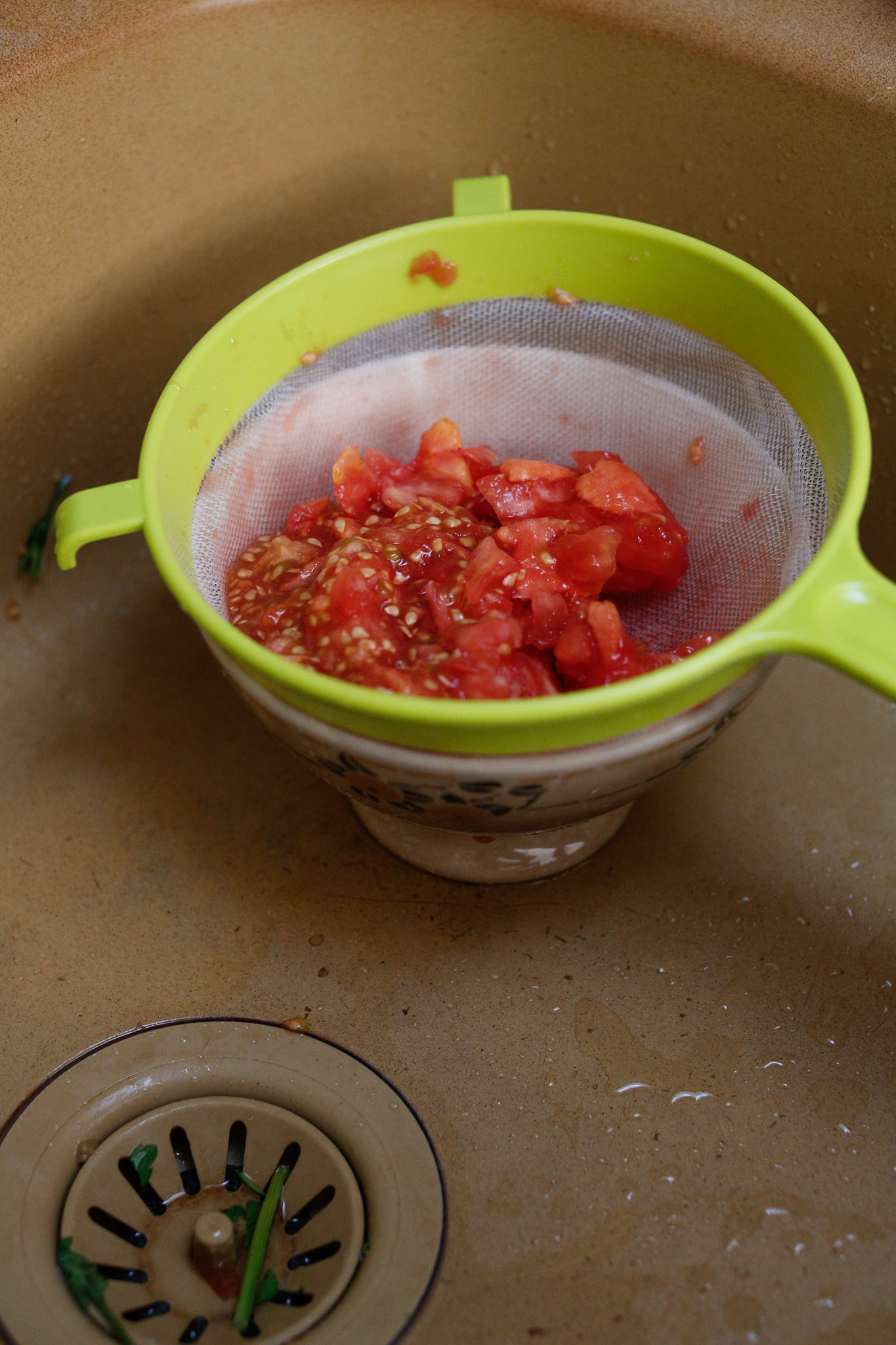 Drain the insides of the tomatos into a bowl to use later when we cook the meat.