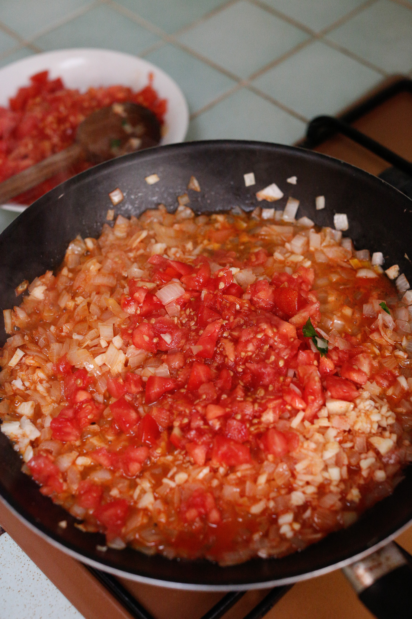 Add in your garlic and half of the pieces of cup up tomatos. It's up to you if you want to add more. It can get too tomatoey tasting.